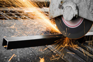 Industrial steel cutting with a disc saw, creating precise cuts and sparks in a fabrication setting